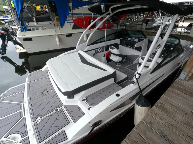 Slide: The Image of 2023 Monterey M-22 boat docked at marina, featuring sleek design and spacious seating. - 12