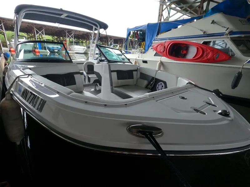 Slide: The Image of 2023 Monterey M-22 boat docked at a marina, featuring spacious seating and sleek design. - 13