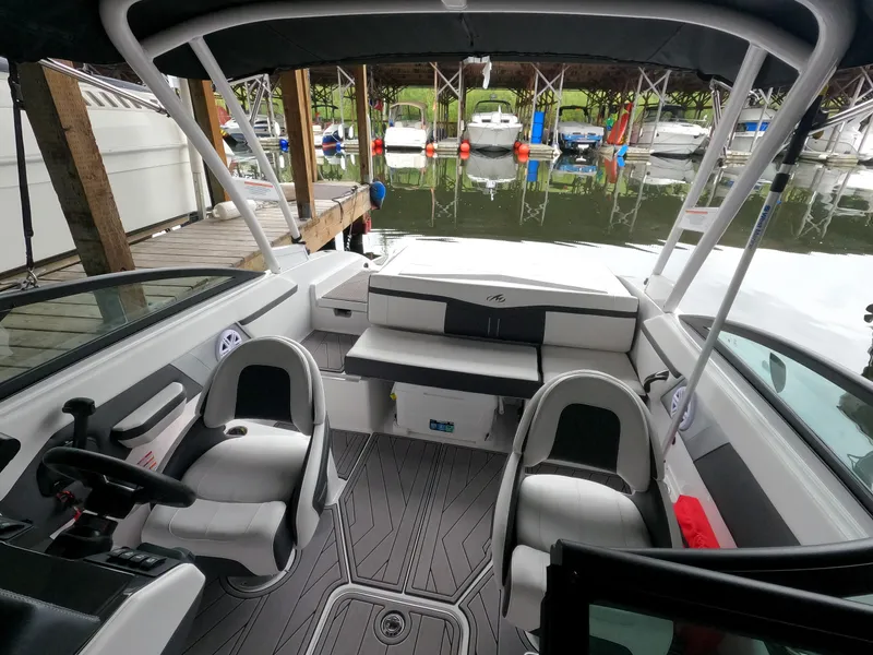 Slide: The Image of 2023 Monterey M-22 boat interior at marina with docked boats in background. - 16
