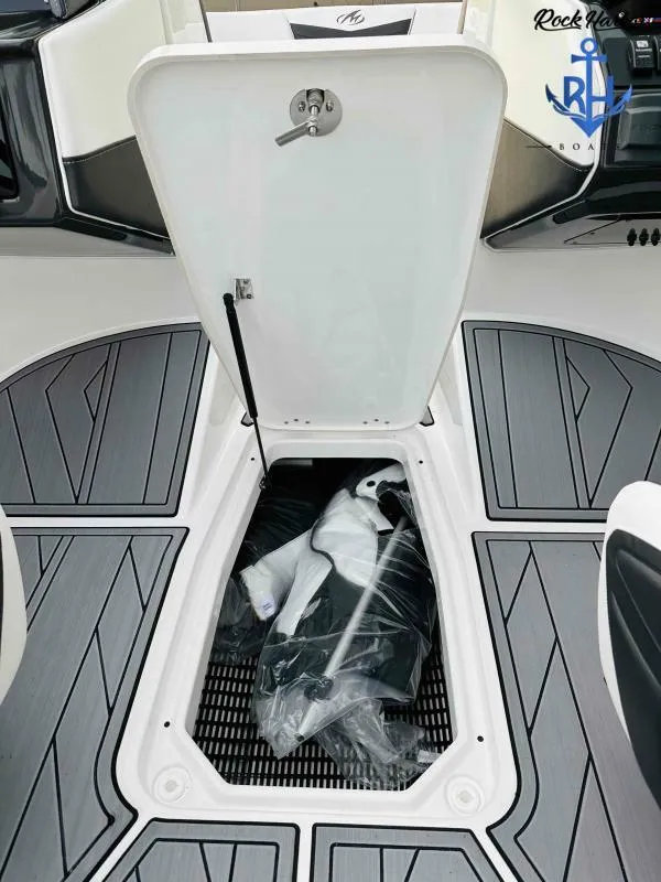 Slide: The Image of 2023 Monterey M-22 boat storage compartment with open hatch and packaged items inside. - 35