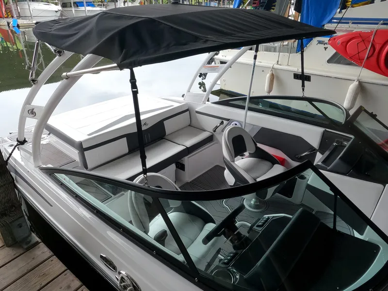 Slide: The Image of 2023 Monterey M-22 boat with black canopy docked at marina. - 8