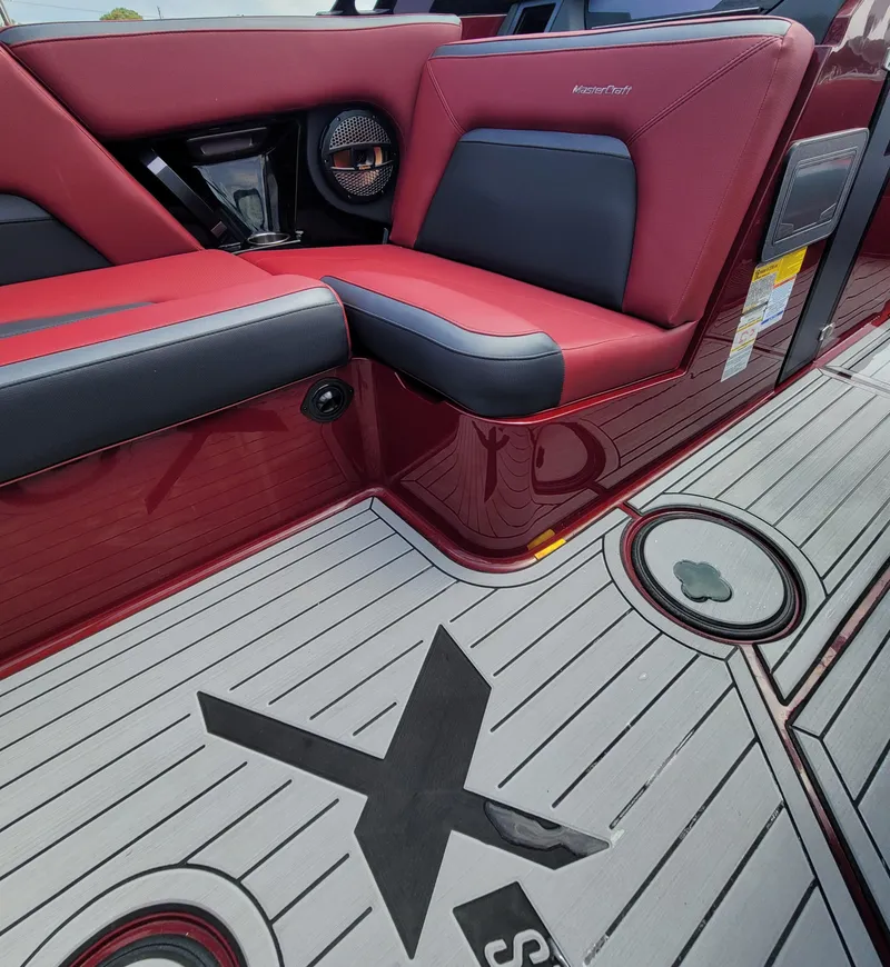 Slide: The Image of 2023 MasterCraft XStar S interior with red and black seating and custom flooring. - 10