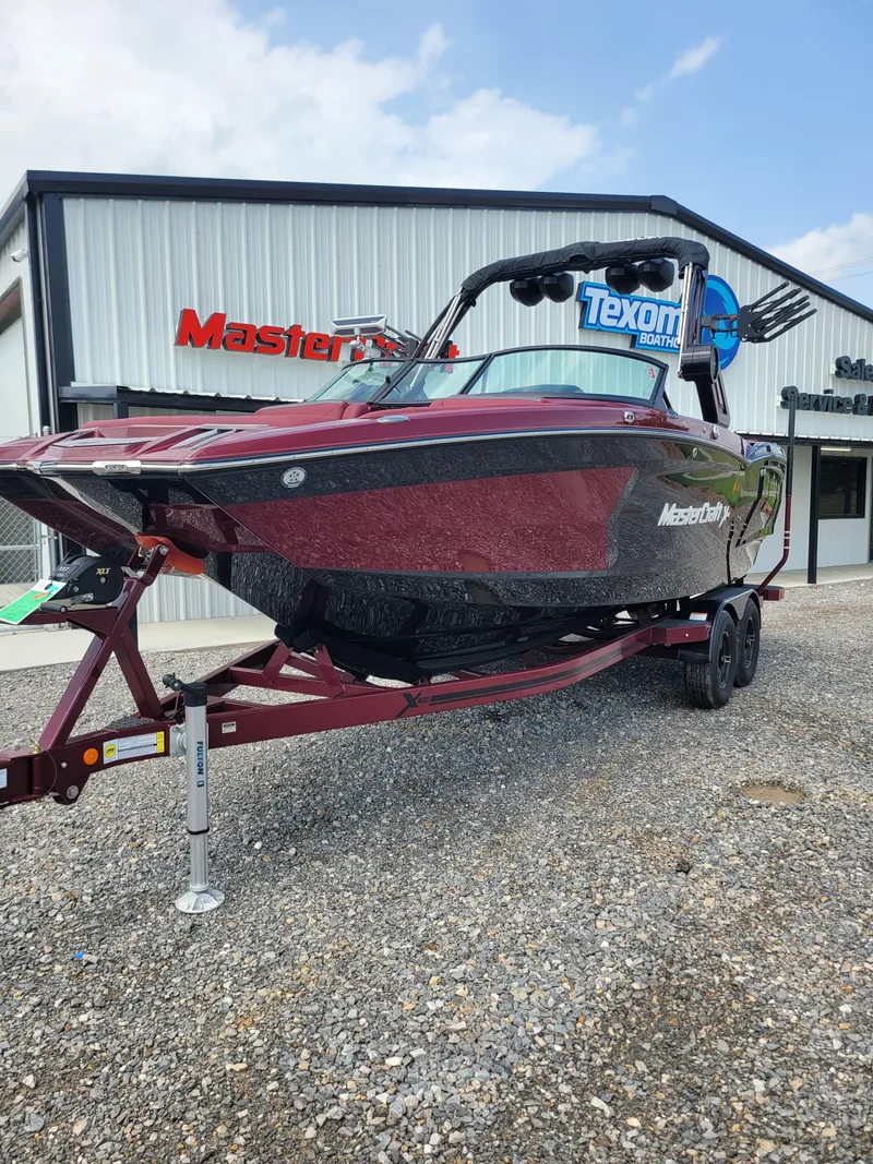 Slide: The Image of 2023 MasterCraft XStar S boat on trailer outside dealership. - 11