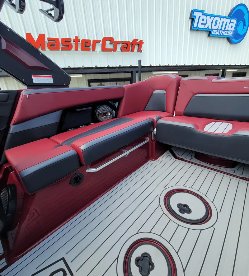 Slide: The Image of 2023 MasterCraft XStar S interior with red and gray seating at Texoma Boathouse. - 12