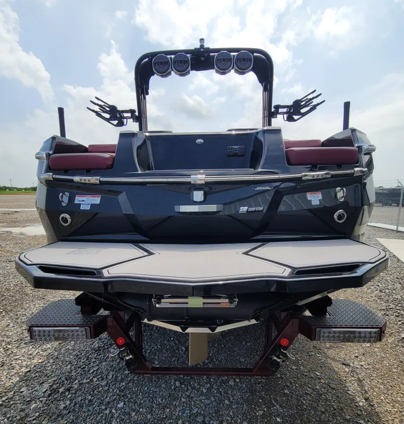 Slide: The Image of 2023 MasterCraft XStar S boat, rear view, sleek design, on gravel surface. - 15