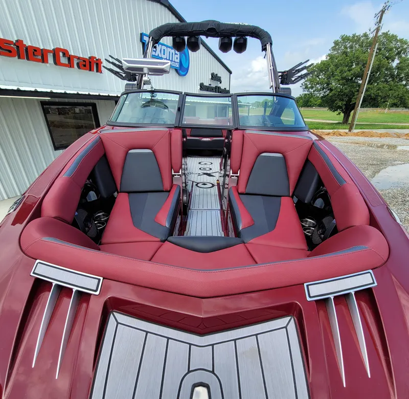 Slide: The Image of 2023 MasterCraft XStar S boat with red and black interior, parked outside dealership. - 16