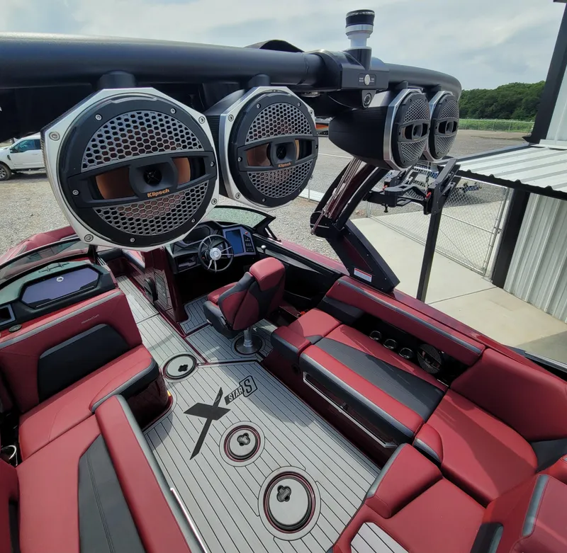 Slide: The Image of 2023 MasterCraft XStar S boat interior with premium speakers and red seating. - 17