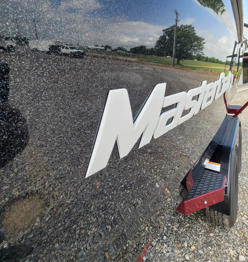 Slide: The Image of 2023 MasterCraft XStar S boat with reflective exterior and logo. - 20