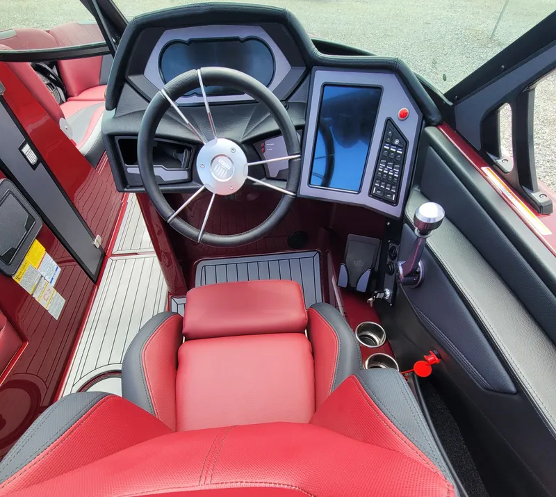 Slide: The Image of 2023 MasterCraft XStar S boat interior with red and black seating, modern dashboard, and steering wheel. - 21