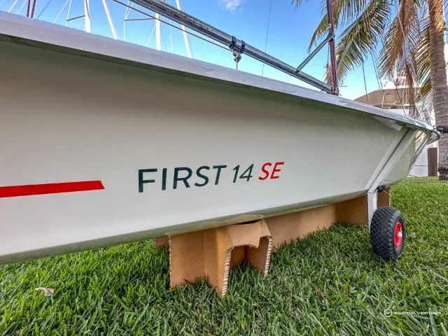 Slide: The Image of 2024 Beneteau First 14 SE sailboat on grass with palm trees in background. - 3