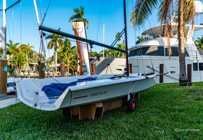Slide: The Image of 2024 Beneteau First 14 SE sailboat on grass near marina with palm trees. - 5