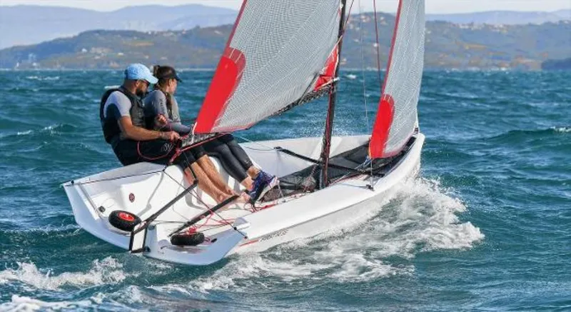 Slide: The Image of 2025 Beneteau First 14 SE sailing on open water with two people onboard. - 9
