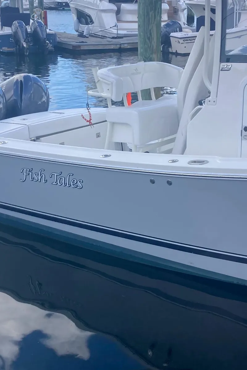 Slide: The Image of 2020 Regulator 23 Forward Seating boat docked, named "Fish Tales." - 14