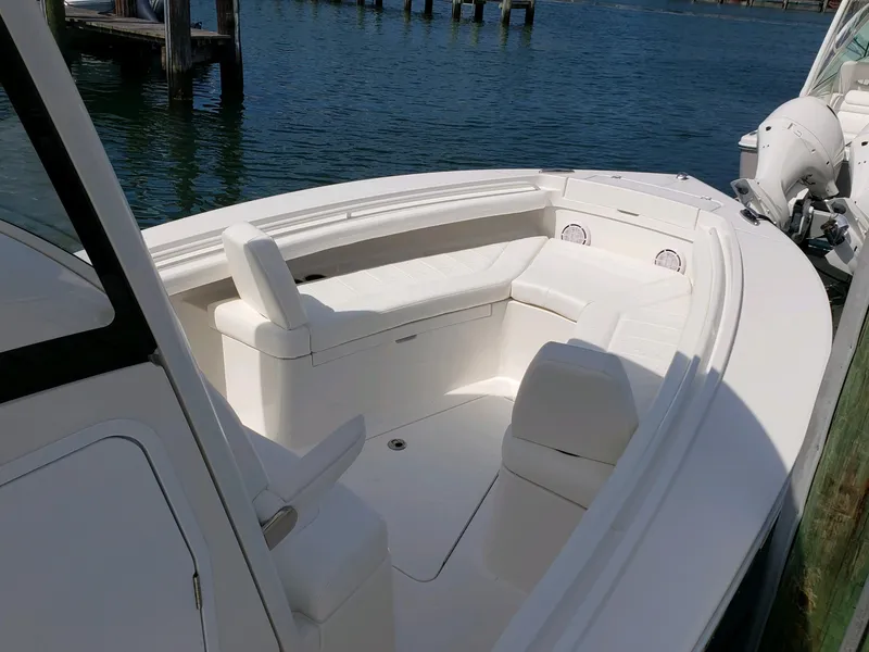Slide: The Image of 2020 Regulator 23 Forward Seating boat with white interior, docked by the water. - 5