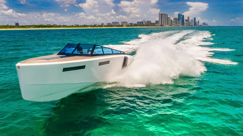 Slide: The Image of 2024 Evo Yachts R4 cruising on turquoise waters near a city skyline. - 11