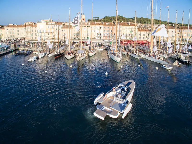 Slide: The Image of 2024 Evo Yachts R4 cruising in a bustling marina with sailboats. - 19