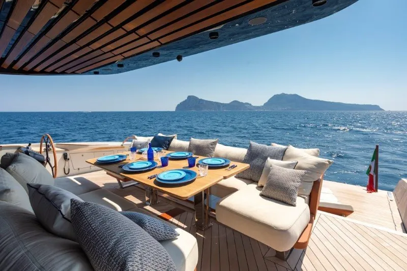 Slide: The Image of Luxury dining area on Evo Yachts V8 2025, with ocean view and island backdrop. - 12