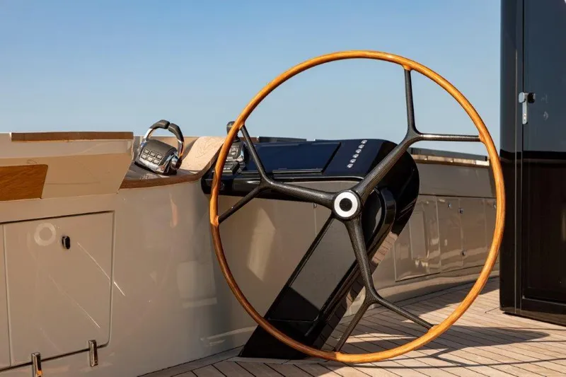 Slide: The Image of 2025 Evo Yachts V8 steering wheel and control panel on deck. - 24