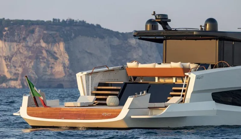 Slide: The Image of 2025 Evo Yachts V8 luxury yacht cruising near rocky coastline. - 7