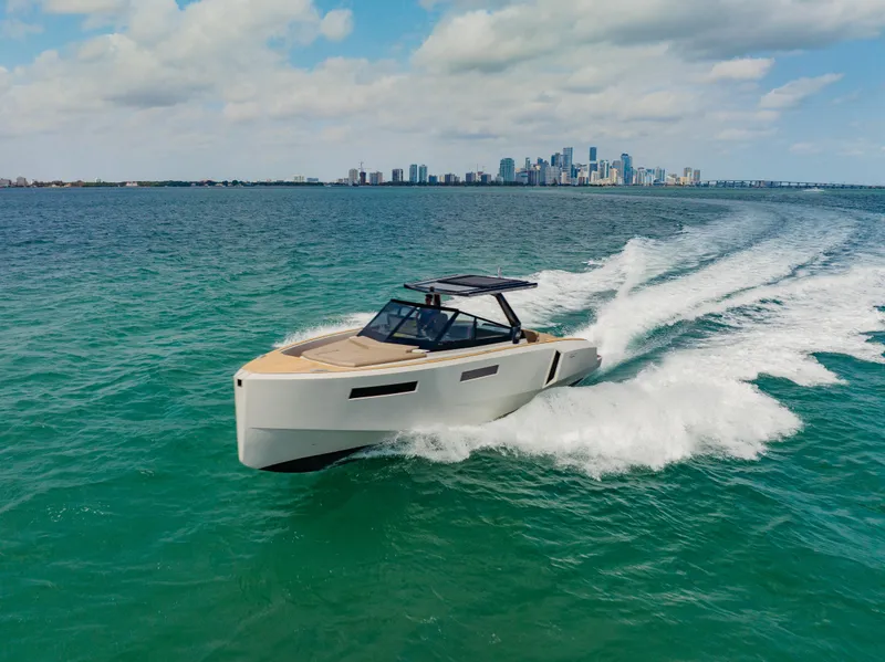 Slide: The Image of 2024 Evo Yachts R4 WA cruising on open water with city skyline in the background. - 19