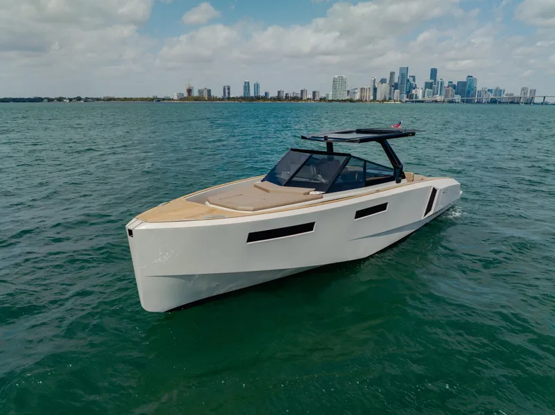 Slide: The Image of 2024 Evo Yachts R4 WA cruising on a calm sea with a city skyline in the background. - 2