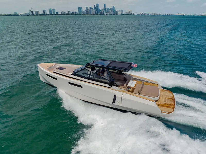Slide: The Image of 2024 Evo Yachts R4 WA cruising on open water with city skyline in background. - 23