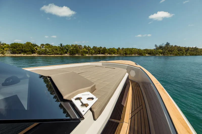 Slide: The Image of 2024 Evo Yachts R4 WA luxury yacht cruising near a tropical shoreline. - 44