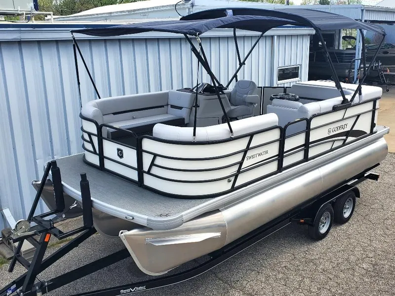 Slide: The Image of 2023 Sweetwater 2086 C pontoon boat on a trailer with a blue canopy. - 11