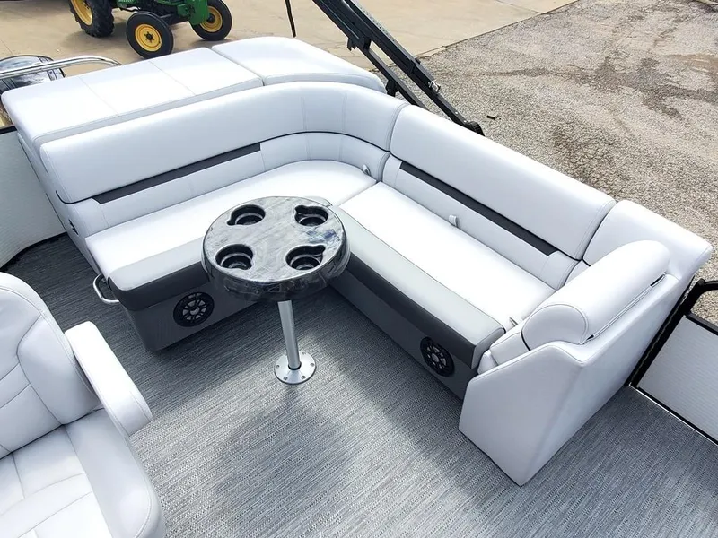 Slide: The Image of 2023 Sweetwater 2086 C pontoon boat interior with white seating and round table. - 5