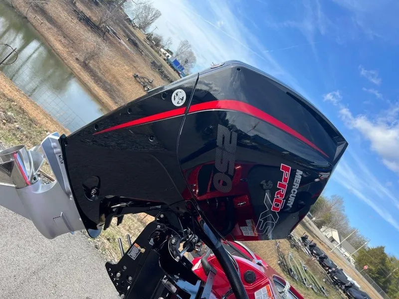 Slide: The Image of 2023 Nitro Z20 Pro boat engine with red and black design near a lake. - 8