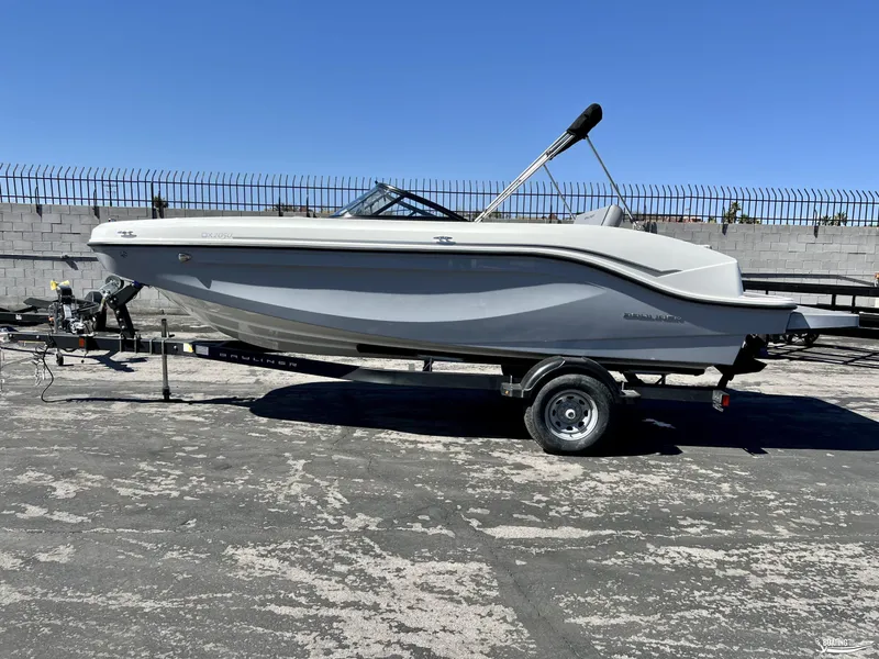 Slide: The Image of 2023 Bayliner DX2050 boat on trailer, parked outdoors under clear blue sky. - 0