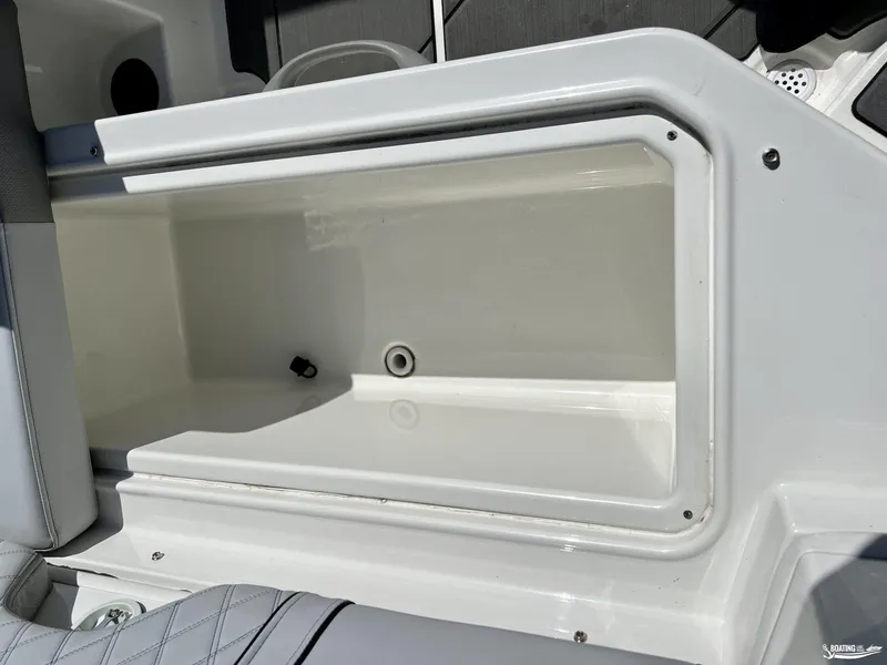 Slide: The Image of 2023 Bayliner DX2050 boat storage compartment, open and empty, with white interior. - 7