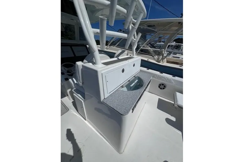 Slide: The Image of 2023 Twin Vee 280 GFX CC boat console with storage and seating area. - 11