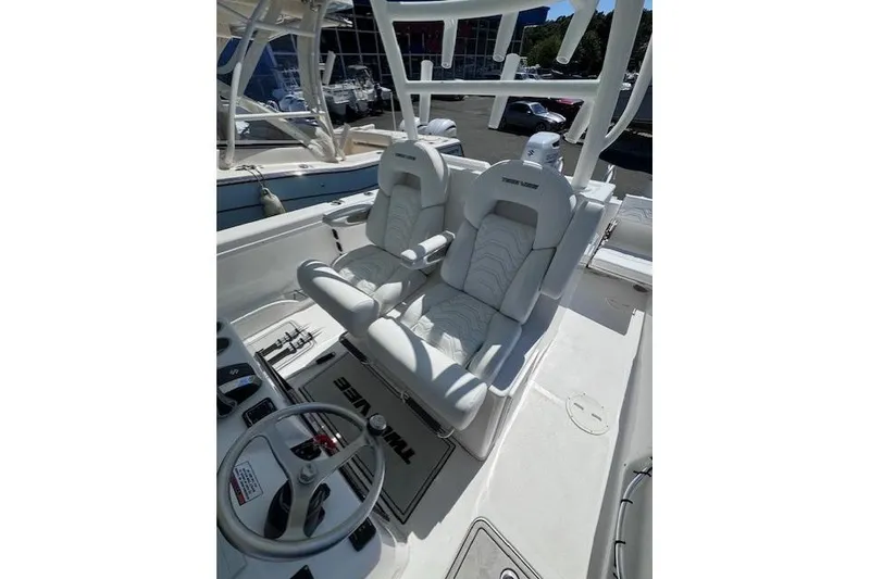 Slide: The Image of 2023 Twin Vee 280 GFX CC boat interior with dual white captain seats and steering wheel. - 13