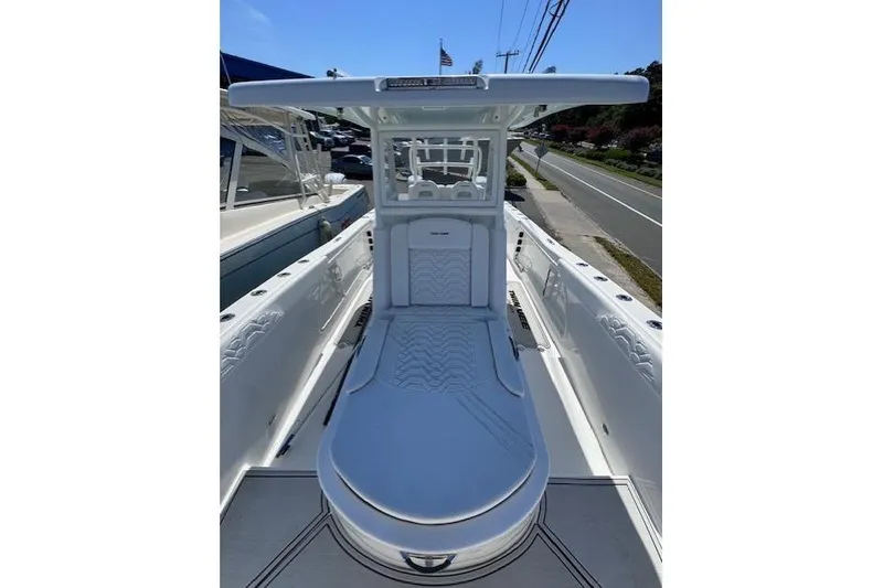 Slide: The Image of 2023 Twin Vee 280 GFX CC boat with sleek white deck and seating, parked roadside. - 18