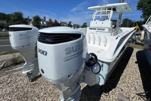 Slide: The Image of 2023 Twin Vee 280 GFX CC boat with dual Suzuki 300 engines, docked outdoors. - 3