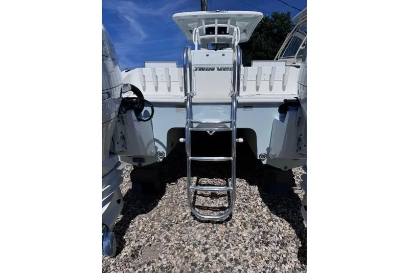Slide: The Image of 2023 Twin Vee 280 GFX CC boat with ladder, rear view under clear sky. - 5