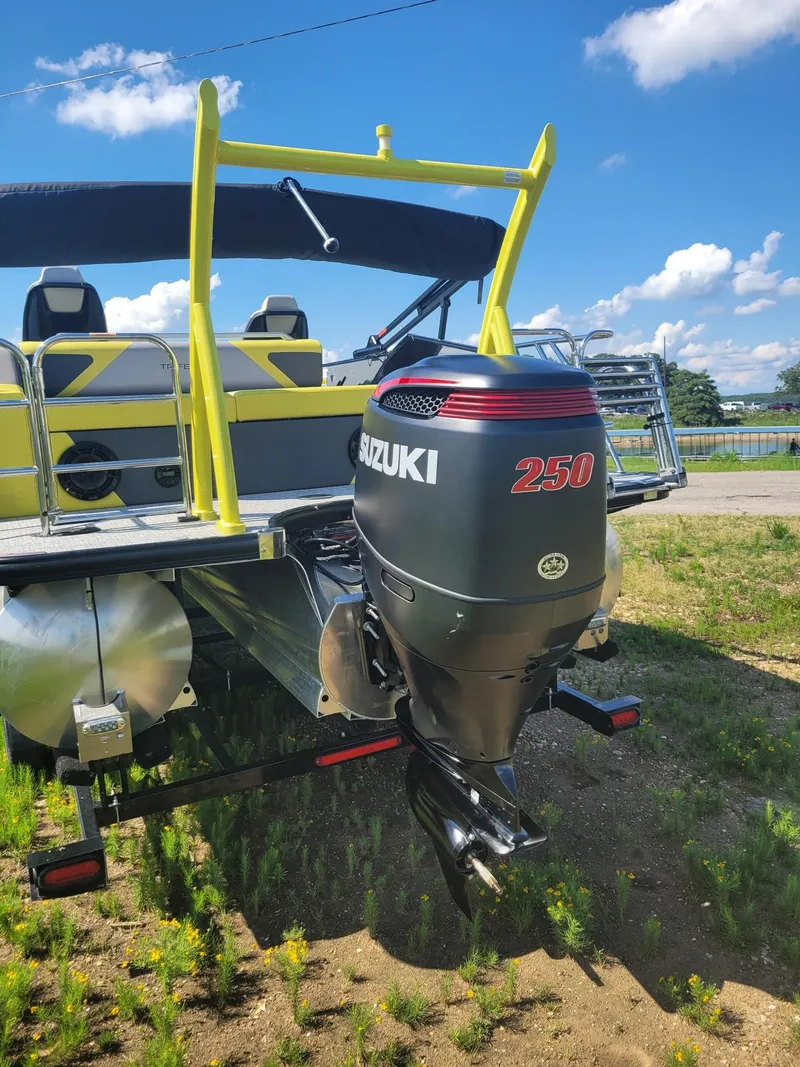 Slide: The Image of Trifecta 2023 23 UL SS boat with Suzuki 250 outboard motor, parked on grass. - 11