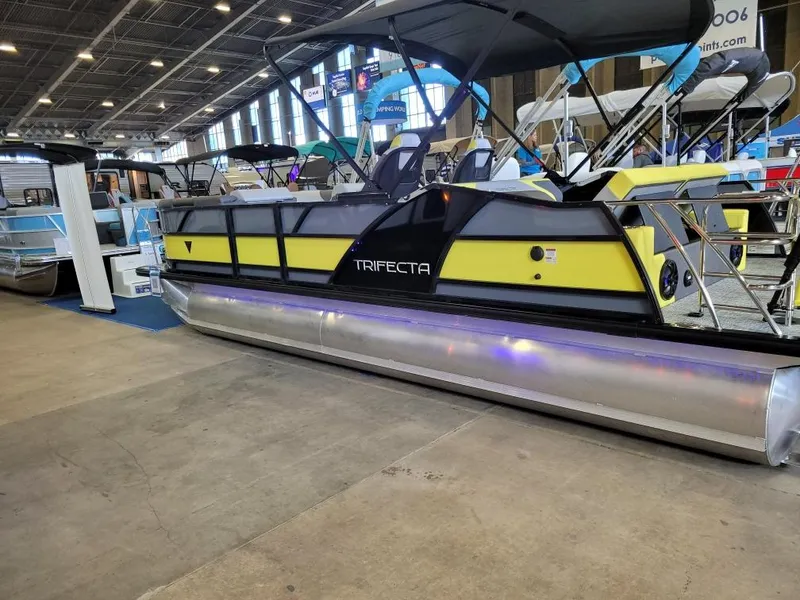 Slide: The Image of Trifecta 2023 23 UL SS pontoon boat displayed indoors at a boat show. - 14