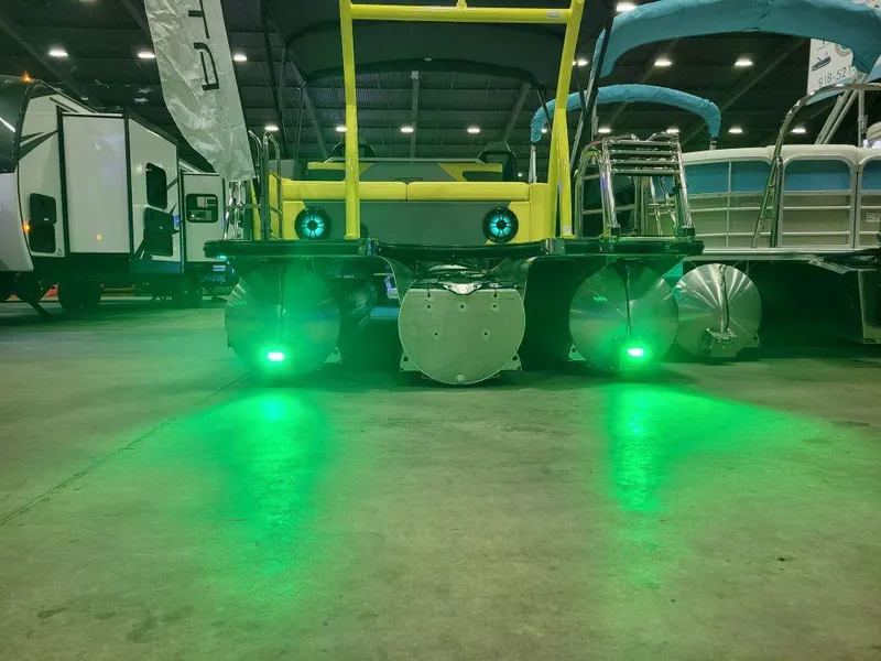 Slide: The Image of Trifecta 2023 23 UL SS pontoon boat with green underwater lights in a showroom. - 18