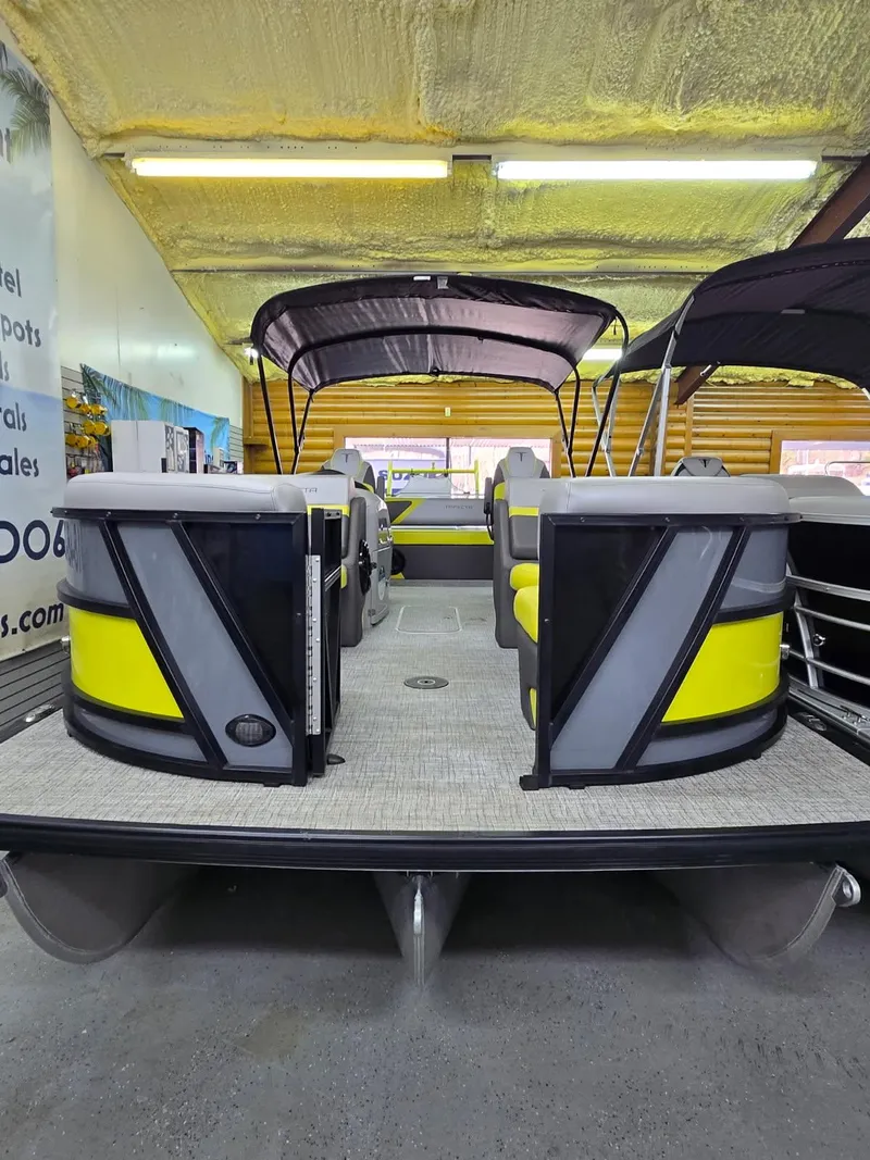 Slide: The Image of 2023 Trifecta 23 UL SS pontoon boat with yellow and gray seating, displayed indoors. - 20