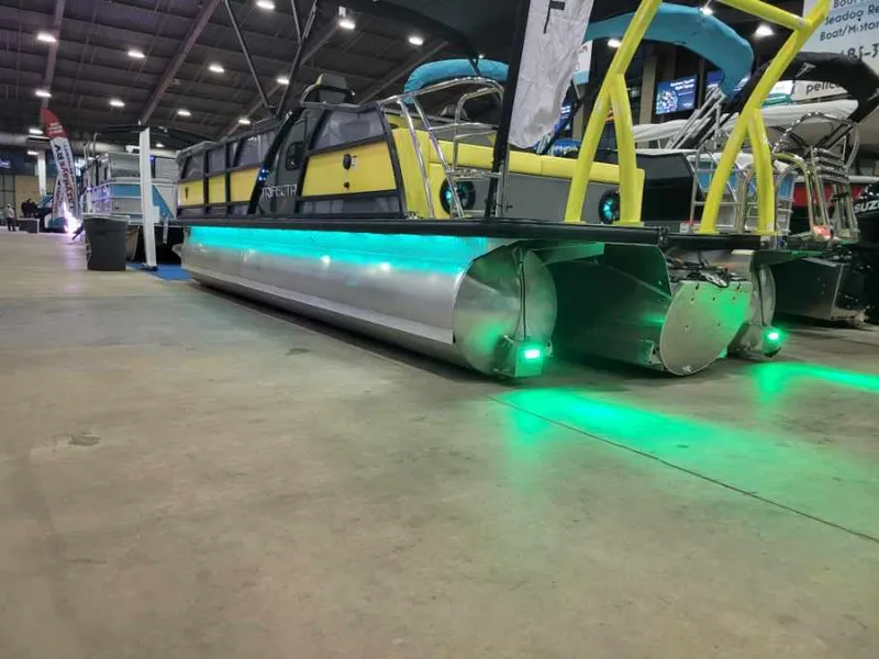 Slide: The Image of 2023 Trifecta 23 UL SS pontoon boat with green LED lights at indoor exhibition. - 3