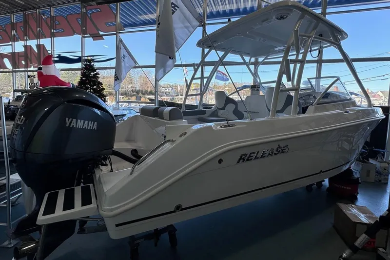Slide: The Image of 2023 Release 230 DC boat with Yamaha engine displayed indoors. - 1