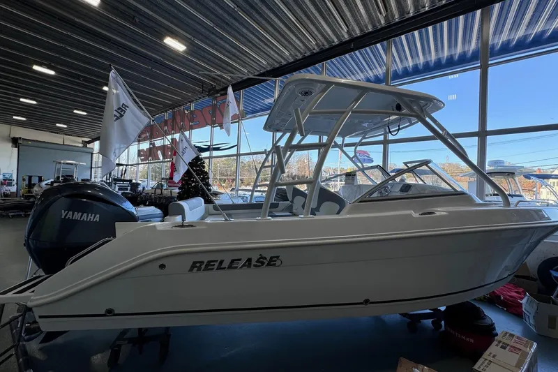 Slide: The Image of 2023 Release 230 DC boat in showroom with Yamaha engine, flags, and large windows. - 10