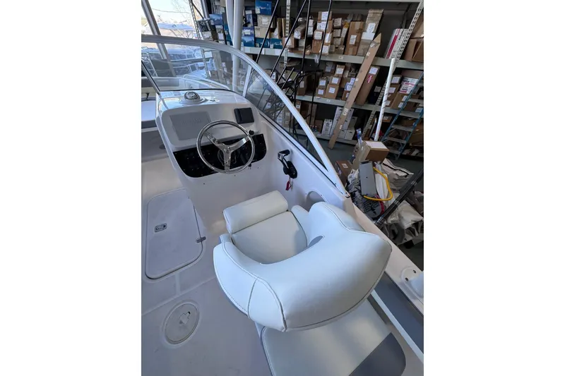 Slide: The Image of Interior of 2023 Release 230 DC boat with white seating and steering wheel. - 8