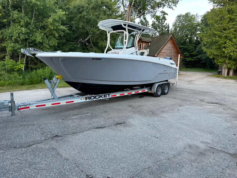 The Image of 2021 Wellcraft 262 Fisherman boat on a Rocket trailer in a wooded area. - 0