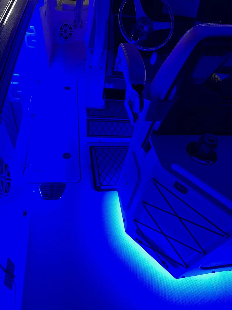 Slide: The Image of 2021 Wellcraft 262 Fisherman boat interior with vibrant blue LED lighting. - 19