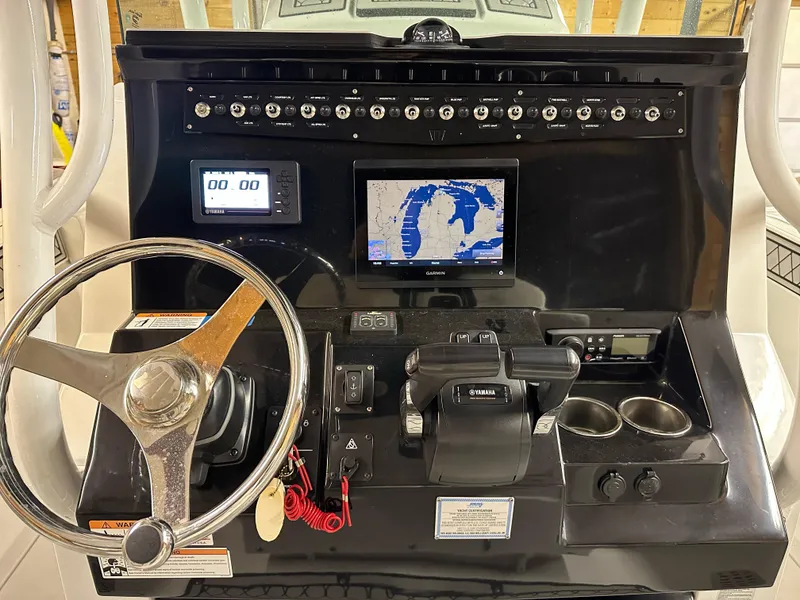 Slide: The Image of 2021 Wellcraft 262 Fisherman dashboard with steering wheel, navigation screen, and controls. - 21