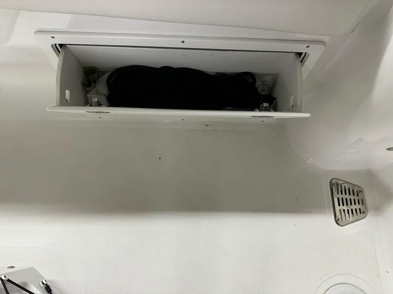 Slide: The Image of 2021 Wellcraft 262 Fisherman storage compartment with black bag inside. - 27