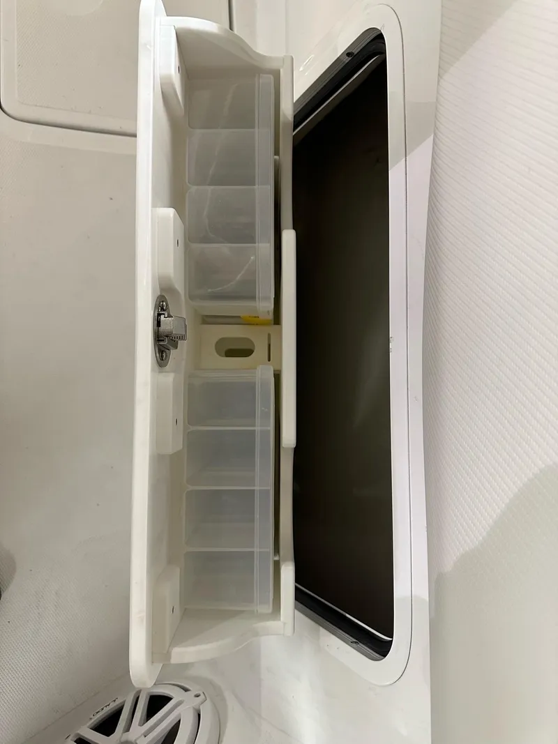 Slide: The Image of 2021 Wellcraft 262 Fisherman tackle storage compartment with organized slots. - 40